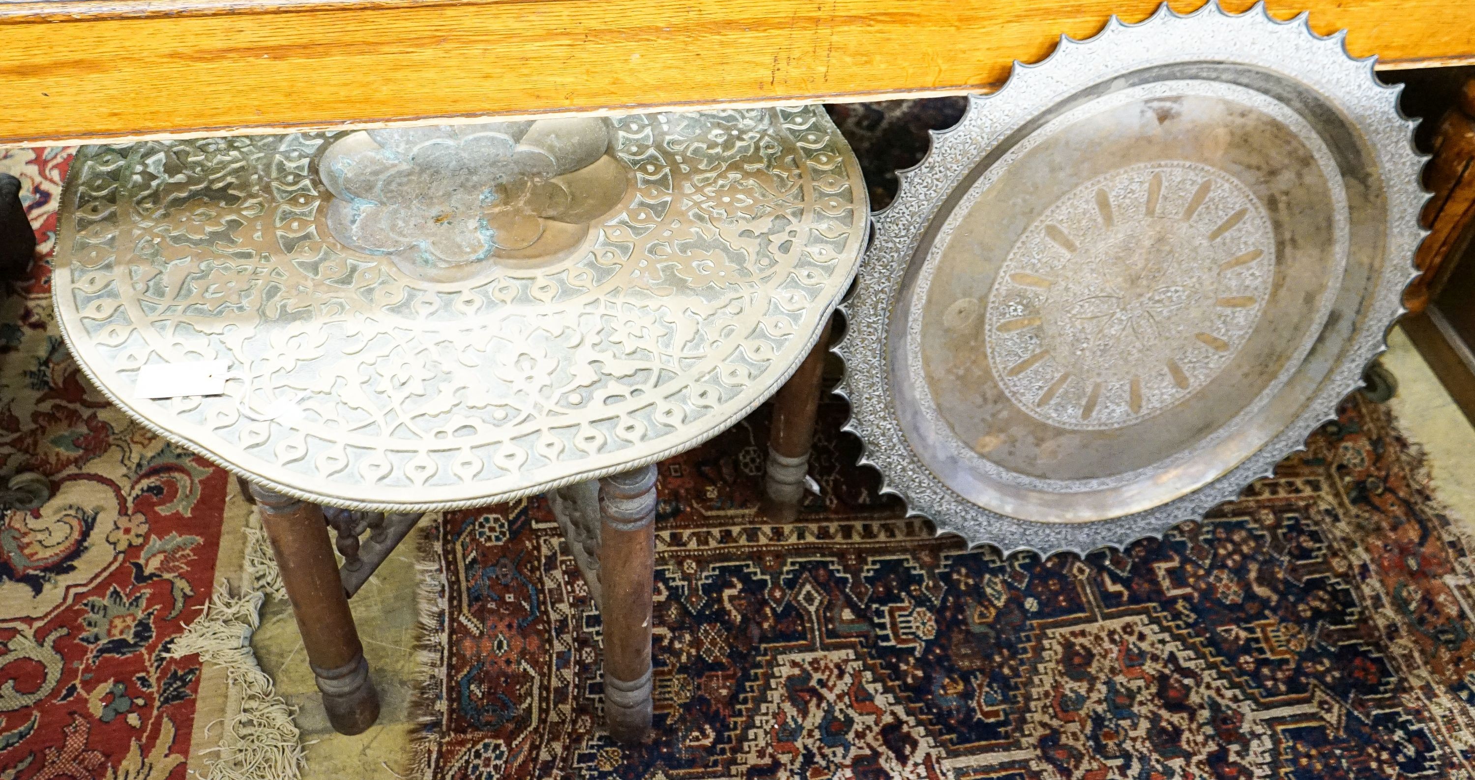 An Indian brass tray top table on folding stand, diameter 74cm, height 56cm together with a circular Indian brass tray